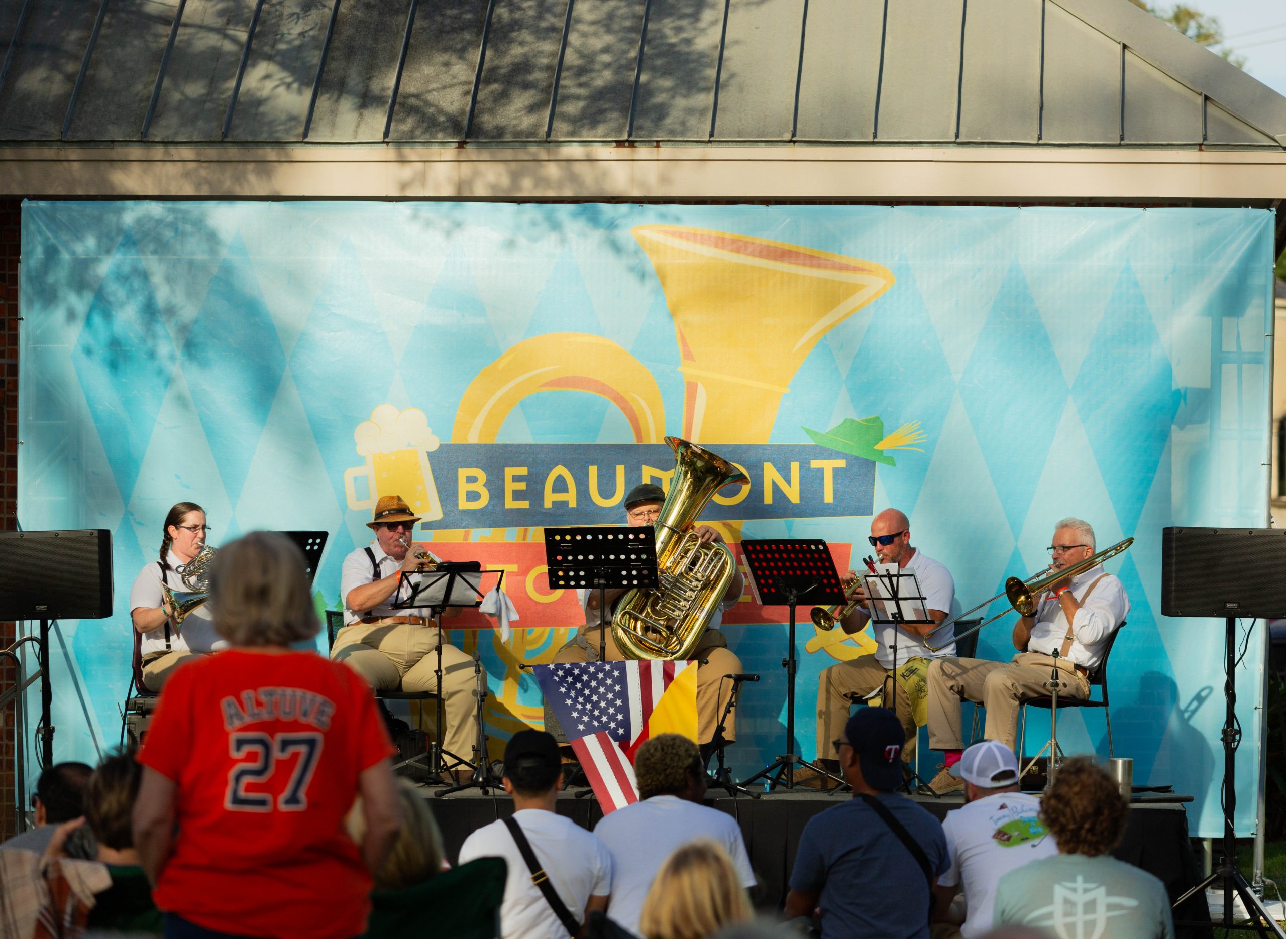 Beaumont band plays music on stage with a large banner behind them.